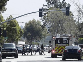 Officers walk near a YouTube office in San Bruno, Calif., Tuesday. (AP Photo/Jeff Chiu)