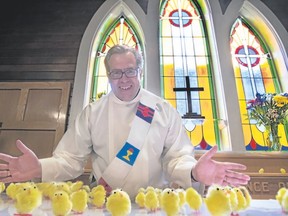On Easter Sunday, St. Michael’s Anglican Church Deacon Sean Krausert embraces dozens of toy chicks on the altar that represent thousands of live chicks that the church has been selling for the Primate’s World Relief and Development Fund. Pam Doyle/ pamdoylephoto.com