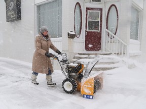 Patricia Lachance uses a snowblower to clean around her business during a snowstorm in Sudbury, Ont. on Wednesday April 4, 2018. The snow made it hard for pedestrians and vehicles to get around town. Environment Canada said Greater Sudbury can expect an increase in cloudiness on Thursday, with a 40 per cent chance of flurries in the afternoon. The high will be -3 C. John Lappa/Sudbury Star/Postmedia Network