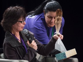 Anni Phillips is given a tissue as she gives her testimony during the National Inquiry of Missing and Murdered Indigenous Women and Girls in Richmond, B.C., Wednesday, April 4, 2018. THE CANADIAN PRESS/Jonathan Hayward
