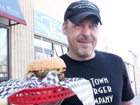 Keith Bramley holds up one of his new burger creations outside the newly renamed Ol’Town Burger Company. Renovation at the new location for the Downtown Diner along 100 Avenue is expected to take two months.