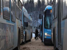 A commuter walks between buses at the Main Terminal in downtown Fort McMurray, Alta. on Tuesday February 17, 2015. Vince Mcdermott/Fort McMurray Today/Postmedia Network