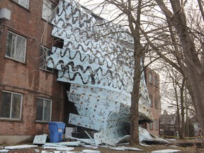 The roof of 885 Division St. hangs over the side of the building after being torn away by high winds in Kingston, Ont. on Wednesday April 4, 2018. With water leaking through the building was evacuated, but no injuries were reported. Steph Crosier/The Whig-Standard/Postmedia Network