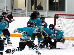 The Novice Cochrane Scorpions celebrate with their goalie Grady Pollock after the team beat Rimbey 7-2 in the gold medal game at the annual Cochrane Hockey in the Rockies Tournament, April 1, 2018.