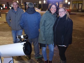 Local residents Tania Forbister and Heather Isaacs, far right, took part in the free telescope viewing in Stoneycreek Village on March 31. The next street astronomy events take place on April 21 and 22 during the first quarter moon. Supplied Image/Gary Andreassen/Fort McMurray Street Astronomers.