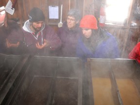 Owen Gray, left, shows, Heather Drummond, second from left, Andrea Grass and Sam Stewart how the evaporator works at Kemlbe Mountain Maple Products on Saturday. The producer was a stop on the Kemble Maple Tour. (Rob Gowan The Sun Times)