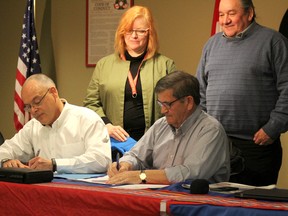 Darryl Hass, ConocoPhillips vice president of health, safety, environment and sustainable development (left) and Peter Hansen, Fort McMurray Metis vice president sign the partnership agreement April 7, 2018. Chantale Campbell, senior coordinator at ConocoPhillips (back left) and Bill Loutitt, CEO of McMurray Metis oversee the signing. Laura Beamish/Fort McMurray Today/Postmedia Network