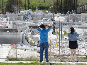 Fort McMurray residents look at destroyed houses covered in tackifier in the Stonecreek neighbourhood of Fort McMurray, Alta., on Monday June 6, 2016. Ian Kucerak/Edmonton Sun/ Postmedia Network