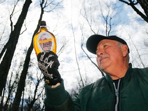 Luke Hendry/The Intelligencer 
Maple syrup producer Ron Hubbs holds a bottle of syrup Tuesday in Hubbs' Sugarbush west of Rednersville. This year the operation has produced about a litre of syrup per each of its 250 tree taps, but producers farther north in central Hastings County are still frustrated by a cold spring that is preventing sap flow.