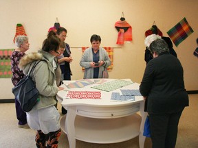 Members of the Peace Country Spinners and Weavers examine some of their work on display at the Fairview FIne Arts Centre during the opening of their show at the Fine Arts Centre.