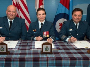 Honorary Col. Tom Hedican, right, relinquishes his appointment to Jacques Lacourse as witnessed by Major B.J. Tinsley, 51 Aerospace Control & Warning (Operational Training) Squadron commanding officer.
Photo by Corporal Robert Ouellette, 22 Wing, CFB North Bay