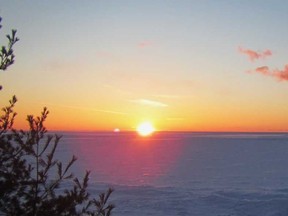 A returning spring sun sets over Lake Superior ice at Montreal River Harbour.