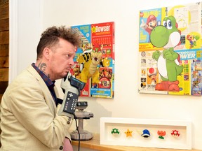 Leigh Cooney, the co-owner of Meet Your Maker Gallery and Gift Shop in Stratford, admires some of the vintage gaming themed art that will be on display during the gallery's Pixel Dreams exhibition, opening this Saturday. (Galen Simmons/The Beacon Herald)