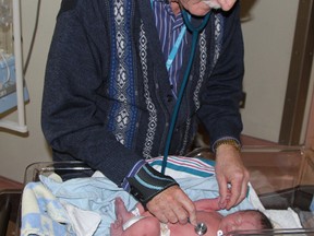 Dr. Gary Smith, chief of neonatal and pediatric medicine at Timmins and District Hospital, checks on Alexander Tait who was born Thursday, four hours earlier to parents Samantha and Leif Tate of Timmins.