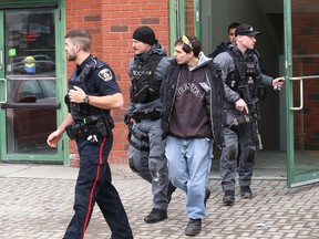 Greater Sudbury Police take a 27-year-old man into custody after he allegedly uttered threats involving explosives at the TD Bank at Durham and Elm Streets in downtown Sudbury, Ont. on Friday April 13, 2018. John Lappa/Sudbury Star/Postmedia Network