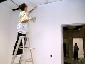 Luke Hendry/The Intelligencer
Debbie Podmilschak, a volunteer with the Canadian Mental Health Association, paints a wall in the association's new office Friday at 250 Sidney St. in Belleville. The association is one of four organizations relocating there to create the Enrichment Hub Quinte, a shared office space.