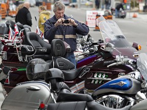 John Bonselaar of Waterford takes photos of a motorcycle that caught his eye during the traditional Friday the 13th gathering  in Port Dover. Cool temperatures made for a lower turn-out of motorcyclists and enthusiasts, but the next event in July is expected to attract more than 100,000 people to the Lake Erie town for the day. Brian Thompson/Postmedia news
