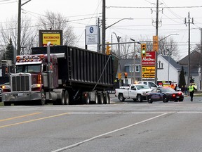 Richmond Street between Lacroix Street and Merritt Avenue in Chatham, Ont., was closed for a time in the early evening of Friday April 13, 2018 as Chatham-Kent police along with crews from public works and Entegrus dealt with several downed wires that were clipped by a transport truck. Police report metal framing mechanism that moves the tarp on this transport trailer was in an up position as the truck travelled along Richmond Street, which caused it to hit and knock down several Bell Canada wires, and fortunately not any hydro wires. The truck is pictured here just before 7 p.m. on Friday parked on Lacroix Street at Richmond Street. Police said the investigation will determine what charges may be laid against the driver. (Ellwood Shreve/Chatham Daily News)