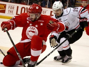 Soo Greyhounds Noah Carroll is chased by Owen Sound Attack Chase Campbell during first-period action of game five of OHL Western Conference semi-final series at Essar Centre in Sault Ste. Marie, Ont. on Friday.