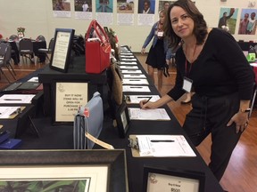 Volunteer Kathy Worrall bids on a Kate Spade purse at the Gems and Java fundraising event on Saturday. (HEATHER RIVERS/SENTINEL-REVIEW)