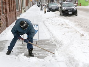 Lenny Morrow shovels the sidewalk on Dundas Street East in downtown Napanee on Sunday during a major storm that descended on much of southern Ontario during the weekend. (Meghan Balogh/The Whig-Standard/Postmedia Network)