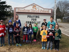 Above, students from Precious Blood Catholic School showed their support for the Humboldt community by sporting a hockey jersey on Thurs., April 12. Behind the students is the school’s sign that reads “Pray for Humboldt” and two hockey sticks are leaned up against it.  (William Proulx/Exeter Lakeshore Times-Advance)