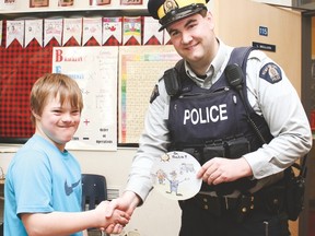 Vulcan Prairieview Elementary School Grade 6 student Tyler Fulton, the winner of the positive ticketing program contest, shakes hands with RCMP Const. Tyler Pearce. His drawing will be used for the logo of the Vulcan Region Positive Ticketing Program, which begins at the end of May. Jasmine O’Halloran Vulcan Advocate