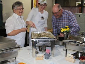 Jodie Russell, president of the Timmins Fur Council, appears set to savour the taste of a rice dish with partridge, just prior to the TFC’s 14th-annual Wildlife Dinner and Dance held Saturday night at the Ramada Inn. There were 25 dishes served at the fundraising dinner was, once again, sold out. The servers here are Lillian McCord, left, and Meghan Mahon.