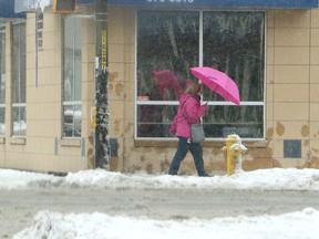 A pedestrian shields themselves from wet snow with an umbrella on Monday. The forecast for the weekend calls for sunny skies and temperatures in the 10-13 C range. (Gino Donato/Sudbury Star)