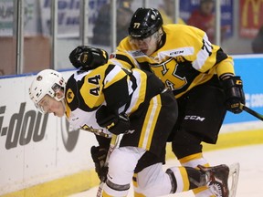 Kingston Frontenac defenceman Eemeli Rasanen tries to hit forward MacKenzie Entwistle of the Hamilton Bulldogs off the puck during the first period of Friday night's game in Kingston, Ont. on Friday, Jan. 19, 2018. Elliot Ferguson/The Whig-Standard/Postmedia Network