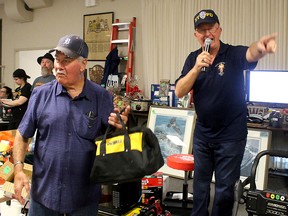 Frank Letourneau, right, loses his voice once a year when he takes on the role of auctioneer during a Wild Game Dinner organized by the Knights of Columbus in Pain Court, Ont. to raise money for families who have children with a disability. Letourneau is pictured with Bob Branquet, left, a founder of the event, on Sunday April 15, 2018, which was the 25th and last dinner organized by the service club. (Ellwood Shreve/Chatham Daily News)