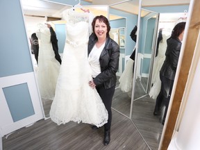 Michelle McCaugherty holds a donated wedding dress in Dawn House’s new, soon-to-open bridal boutique. (Meghan Balogh/The Whig-Standard)