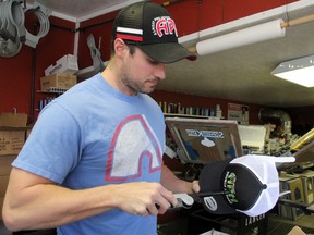 Kyle Chagnon has been busy filling orders for Broncos Strong caps in the past week. The APH business owner in Kenora had about 300 orders come in online between April 9 and 12 before he had to close the site due to the backlog. SHERI LAMB/Daily Miner and News/Postmedia Network