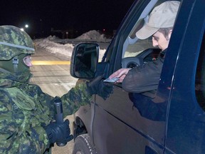 A Wing Auxiliary Security Force member checks a driver’s identification during a previous exercise at 22 Wing / Canadian Forces Base North Bay.
Photo by Cpl Joseph Morin