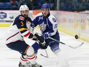 Zach Wilkie, right, of the Sudbury Wolves, fires the puck past Cameron Lizotte, of the Barrie Colts, during OHL action at the Sudbury Community Arena in Sudbury, Ont. on Friday January 22, 2016. John Lappa/Sudbury Star/Postmedia Network