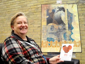 London artist Marijo Swick holds a brochure for the upcoming London Artists’ Studio Tour in front of one of her paintings. Swick and many other local artists will open up their studios to the public this weekend. (CHRIS MONTANINI\LONDONER)