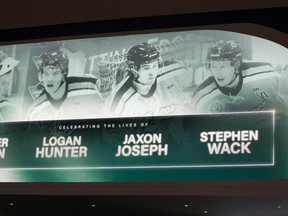Photos of Edmonton-area Humboldt Broncos players Jaxon Joseph, Logan Hunter, Parker Tobin and Stephen Wack are visible on a screen as Edmontonians head into a public memorial for the four at Rogers Place in Edmonton Tuesday, April 17.