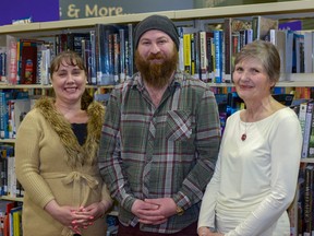 Library Manager Miranda Johnson, musician Brandon Lorenzo, and author Betty Jane Hegerat pose together at the Airdrie Public Library on April 7. The library will be hosting authors to discuss their work throughout the year.