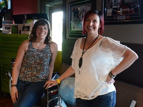 Kari Broadhurst (left) and Kendra Watt (right), best friends and organizers of the Hair of the Dog event, pose with a moped that was donated to the silent auction by Watt at the Venue in Cochrane on Saturday, April 14, 2018.