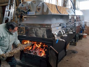 Greg Romanow, Bill Hallatt's friend and a helper at the Pancake Point Maple Syrup sugar house, loads the evaporator with firewood. Wood-fired sap makes for a darker syrup with a more robust maple flavour.