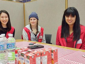 Queen's University Blood Team First Year Outreach coordinator Lauren Beck, and general executive Amanaat Gill along with a volunteer during a blood clinic during November of 2017.