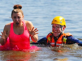 Ceilah Sagar shows the water is "tutu" cold as Belleville firefighter Ryan Turcotte laughs during the third-annual Freezin' for a Reason YMCA event in Belleville. Sagar was one of 29 people to enter the chilly Bay of Quinte. They raised $13,097 for the local YMCA's Strong Kids campaign to allow children to take part in day-camp activities.