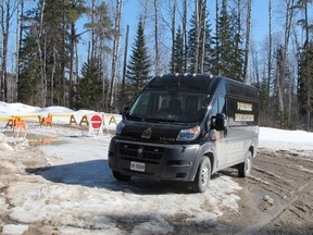 A Timmins Police Service forensic identification van is seen parked on Dalton Road, in front the barriers where Price Road has been closed. Six kilometres beyond this barrier, police say a charred 2004 Chrysler Intrepid was discovered with the human remains of four individuals. (RON GRECH/Postmedia)