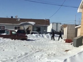 A screen capture from a video shared with The Daily Press on Facebook shows two armed NAPS officers approaching a man in front of a home in Attawapiskat last Thursday. This image occurred 45 seconds after the shots were fired. The lone man went into his house and emerged moments later with his hands in the air.