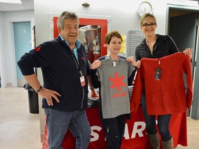 Bruce Dickson (left), STARS Air Ambulance representative, with local residents holding STARS merchandise. (Taryn Brandell | Mayerthorpe Freelancer)