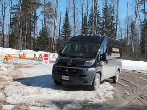 A Timmins Police Service forensic identification van is seen parked on Dalton Road, in front the barriers where Price Road has been closed. Six kilometres beyond this barrier, police say a charred 2004 Chrysler Intrepid was discovered with the human remains of four individuals. (RON GRECH/Postmedia)