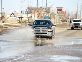 A driver makes his way down 116 Street near 84 Avenue with his truck covered in water as melting snow floods the streets on Monday in Grande Prairie. City crews placed signs recommending drivers slow down to 30 km/h.