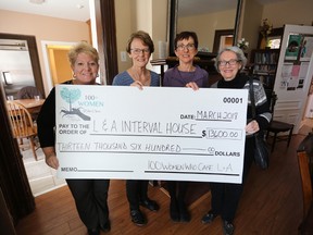 Interval House executive director Sue Weir, left, receives a donation to the Interval House from Lennox and Addington 100+ Women Who Care’s “leading ladies” Deb Lowry, Barb Delaney and Wendy Conlon on Monday. (Meghan Balogh/The Whig-Standard)