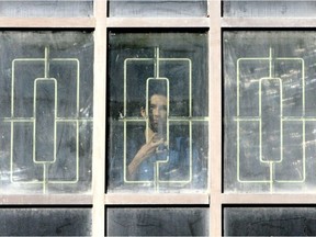 An inmate looks out a window at the Edmonton Remand
Centre.