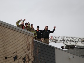 The five firefighters participating in the annual 100-hour rooftop campout wave to the crowd on Tuesday, April 18, 2017 at noon to kick off their stay ontop the Tim Horton's in Eagle Ridge until 4 p.m. April 22, 2017. Olivia Condon/ Fort McMurray Today/ Postmedia Network